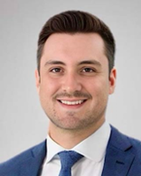 A person in a suit and tie  Description automatically generated